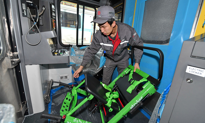 能下楼梯的折叠轮椅、便携式应急担架、灵活的翻折座椅等诸多设施成为“中国制造”波士顿地铁的亮点。波士顿地铁是美国第一条地铁，自1897年投入使用至今已有100多年历史。10月31日，在中车长客客车制造中心装配一车间，工人调整波士顿地铁列车上配备的折叠轮椅。（新华社记者 张楠 摄）