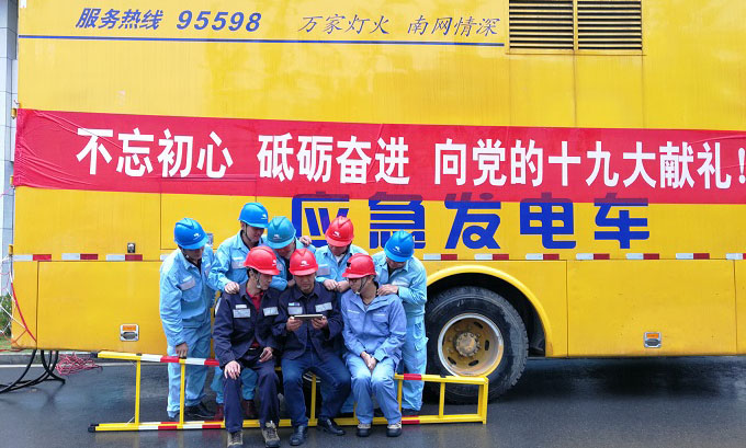 图为南方电网贵州公司保电员工在工作待命期间通过手机收看党的十九大开幕会盛况。