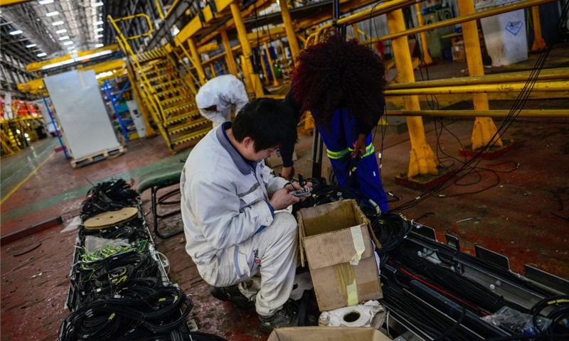 这是7月27日，中南两国技术人员在南非比勒陀利亚南非运输集团工厂进行机车接插件制作。（新华社记者 翟健岚 摄）