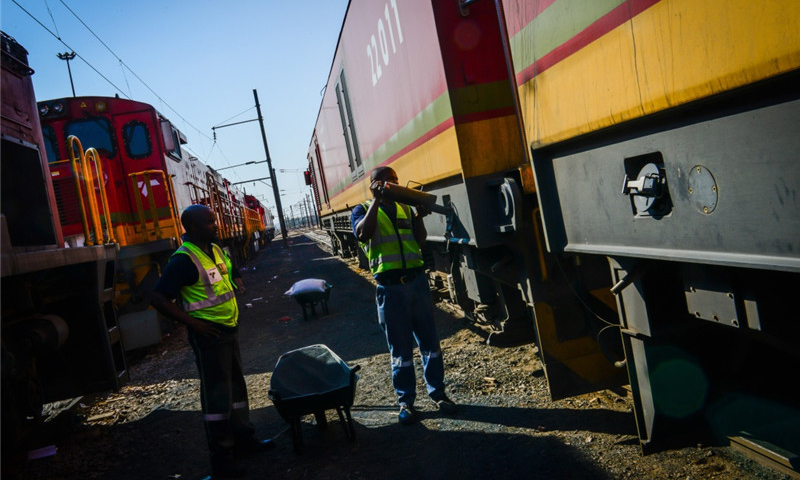 这是7月27日，在南非比勒陀利亚北部的一个机务段，一名工人为一台中国机车的沙箱加沙。（新华社记者 翟健岚 摄）