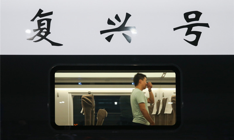 6月26日，在上海虹桥火车站，乘客在“复兴号”G124次列车内行走。（新华社记者 丁汀 摄）