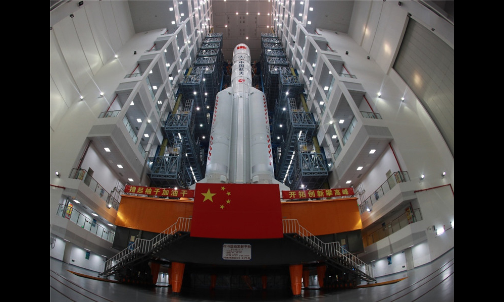 6月26日，由中国航天科技集团公司抓总研制的长征五号遥二火箭，在中国文昌航天发射场完成技术区相关工作后，垂直转运至发射区，计划于7月2日至7月5日择机发射。（张文军 摄）