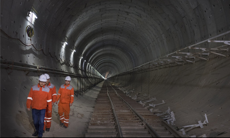参建人员行走在贯通的白城隧道内。（新华社记者 陶明 摄）