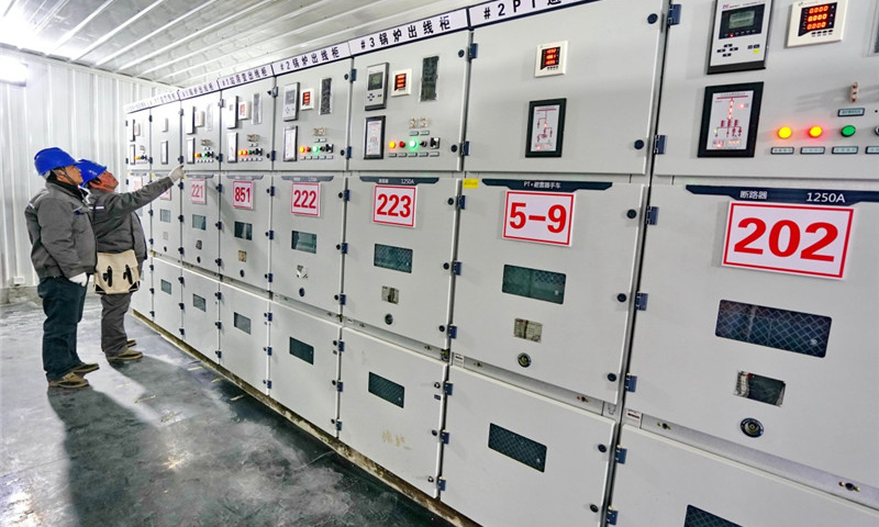 12月14日，国网怀来县供电公司工作人员在帮助供暖单位检查蓄热式电锅炉的供电设备。（新华社记者 杨世尧 摄）