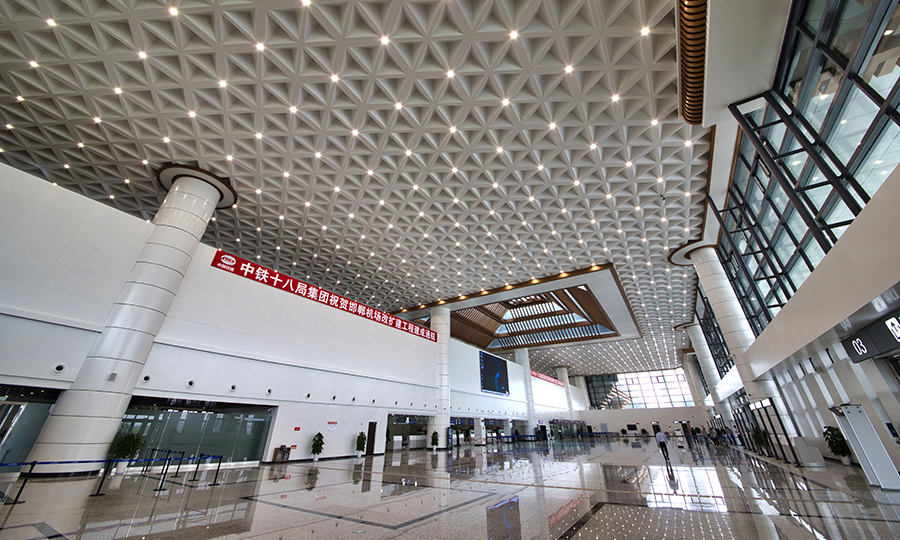 其中，建筑面积近2万平米的航站楼，采用了中国传统古建筑造型与现代设计理念完美融合的“飞檐华盖”新结构，大面积采用了倾斜式的玻璃幕墙和顶部镂空的古典造型，最大限度提升自然采光效果，减少室内灯光照明，有效节约能耗，使我国个性化机场建设的环保理念和施工经验日趋完善。