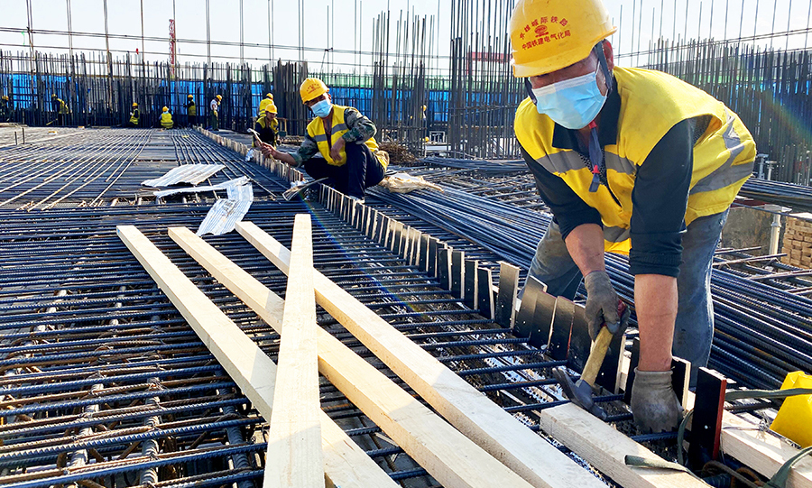 图为中铁建电气化局三公司京雄城际铁路项目部员工在雄安牵引变电所固定绑扎的钢筋。