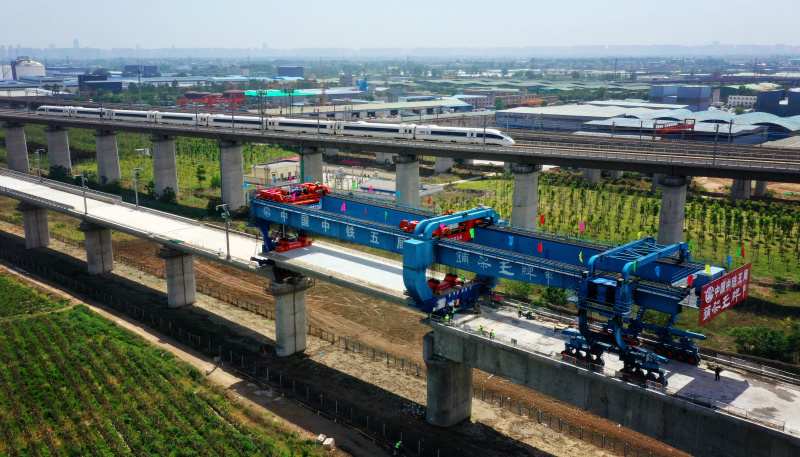 图为5月10日，工人在银西高铁咸阳渭河特大桥上架设全线最后一榀箱梁。（新华社记者 刘潇 摄）