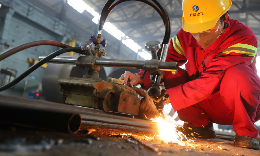 图为2月13日，广西建工集团冶建公司压力容器制造厂工人们戴口罩，经测体温后进入消毒过的生产车间进行切割作业。