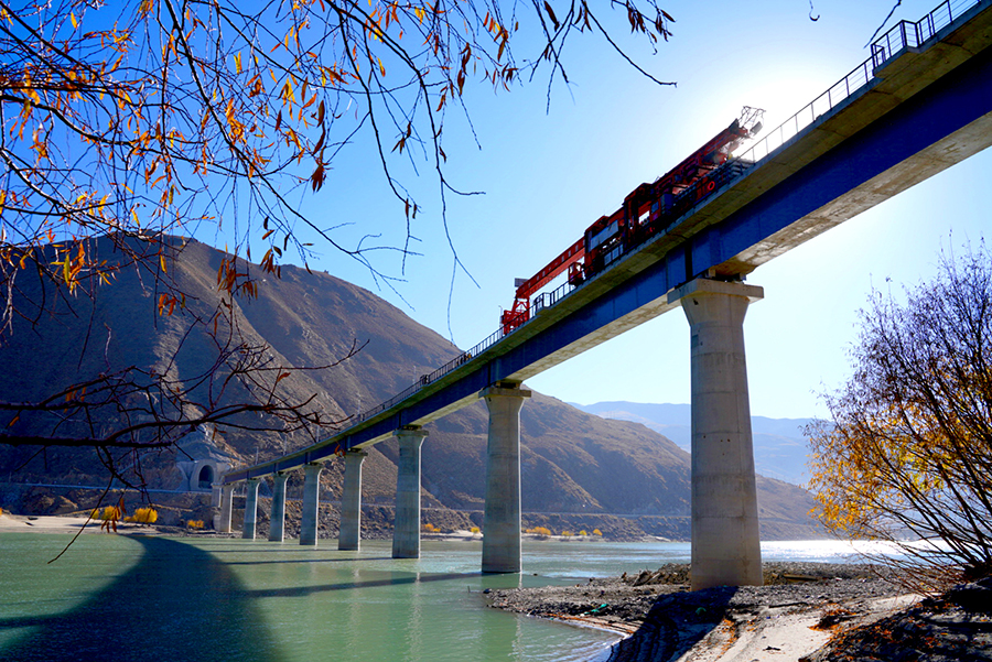12月1日，拉林（拉萨至林芝）铁路绒乡雅鲁藏布江特大桥完成铺轨，这是拉林铁路第二次跨越雅鲁藏布江。拉林铁路全长435.48公里，设计时速160公里，是西藏首条电气化铁路，共跨越雅鲁藏布江16次。图为中国铁建所属中铁十一局绒乡雅鲁藏布江特大桥铺轨现场。（丁庆滨 摄）