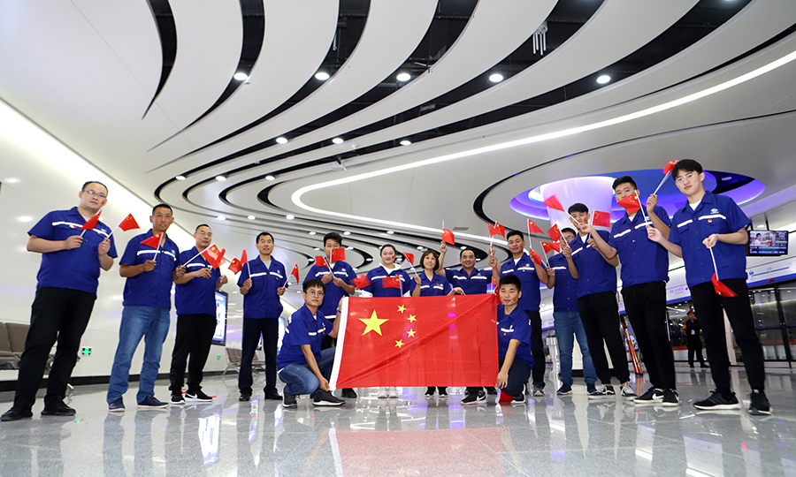 图为建设者在北京大兴国际机场地铁线草桥站与国旗合影（范成涛 摄）