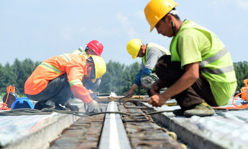 图为7月9日，工人在京哈高速长春至拉林河段改扩建工程现场进行高速路面施工。（新华社记者 林宏 摄）