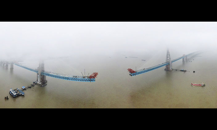 图为6月27日，无人机拍摄沪通长江大桥南主塔（左）成功封顶画面。（新华社记者 许丛军 摄）