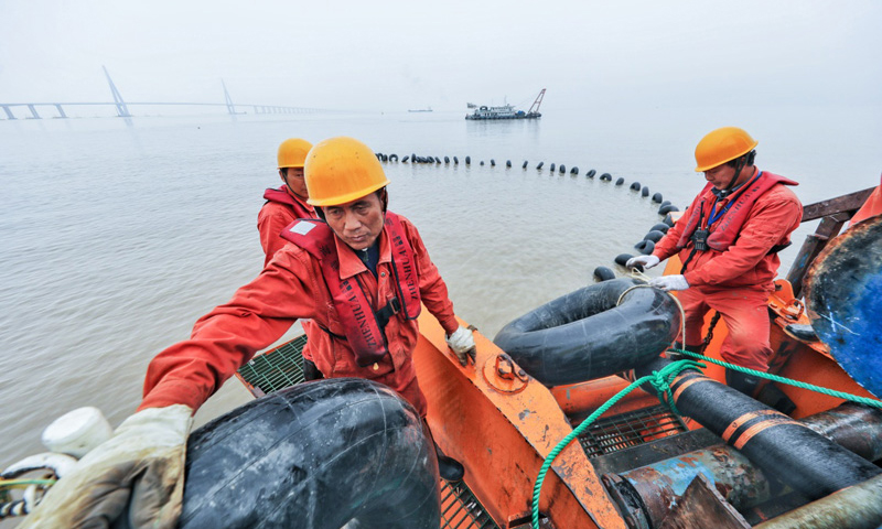 图为6月2日，工作人员把最后一段海底电缆用拖船拖向舟山大鹏山岛。（新华社记者 徐昱 摄）