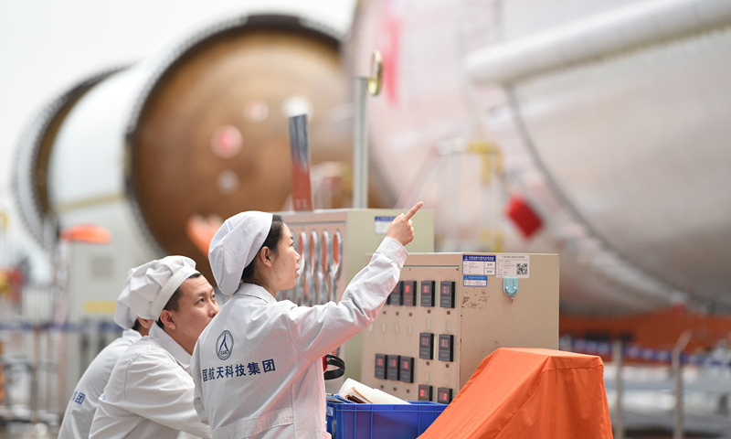 图为工作人员在天津新一代运载火箭产业化基地长征五号总装测试车间对火箭进行检查。