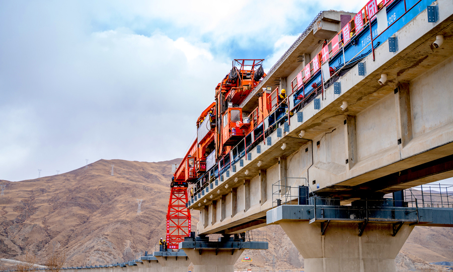 3月19日，在西藏自治区山南市贡嘎县杰德秀Ⅰ号大桥铺架施工现场，中国铁建所属中铁十一局三公司作业人员开始架设拉林铁路首座声屏障T梁，打造无噪音污染的“绿色”新天路。图为架桥机正在架设拉林铁路首座声屏障桥梁。