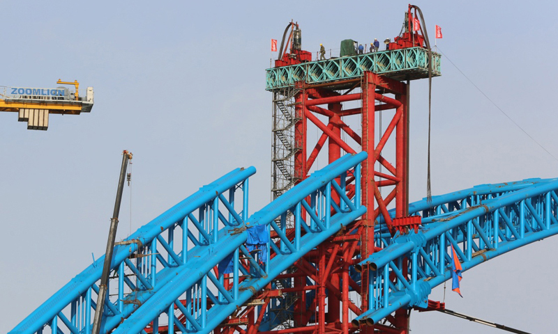图为3月11日，施工人员在汉十高铁崔家营汉江特大桥主拱上进行抬升作业。新华社发（杨东 摄）