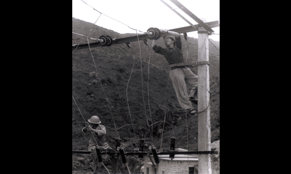 图为上世纪70年代，横琴岛电力工人在维修供电线路。