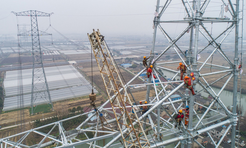 图为2月1日，施工人员正在新建铁塔上进行施工作业。（新华社记者 徐昱 摄）
