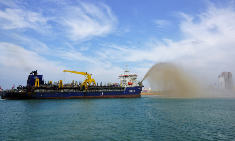 图为2017年12月16日，在斯里兰卡科伦坡港口城项目施工现场，一艘中国耙吸挖泥船正在吹沙。（新华社记者 唐璐 摄）