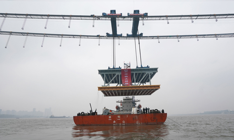 图为11月15日，缆载吊机在吊装重达1000吨的钢梁。（新华社记者 程敏 摄）