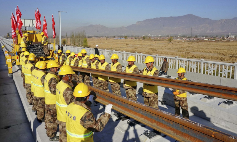 图为11月1日，在京张高铁河北怀来段铺轨现场，中铁三局的工人正在铺设京张高铁全线第一节轨排。（新华社记者 杨世尧 摄）