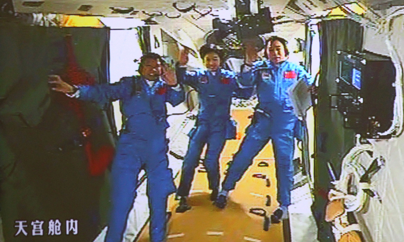 北京航天飞控中心大屏幕显示航天员景海鹏、刘洋、刘旺（从右至左）在天宫一号实验舱内（2012年6月18日摄）。（新华社记者 查春明 摄）