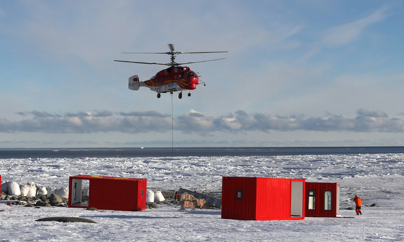 船载“雪鹰12”Ka－32直升机将物资吊运至恩克斯堡岛新建站区（2017年12月9日摄）。（新华社记者 白国龙 摄）