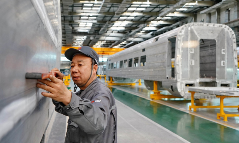 今年3月9日，唐车研制的我国首列时速350公里长编组“复兴号”中国标准动车组开始型式试验，这是16辆编组“复兴号”在全球的首次亮相，成为新时代中国高铁走向世界的“大国重器”。图为中车唐山机车车辆有限公司的工人在动车组生产线上工作。（新华社记者 杨世尧 摄）