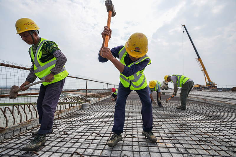 图为5月1日，工人在珠海鹤港高速公路二期工程高栏港枢纽立交桥建设现场施工。（新华社记者 刘大伟 摄）