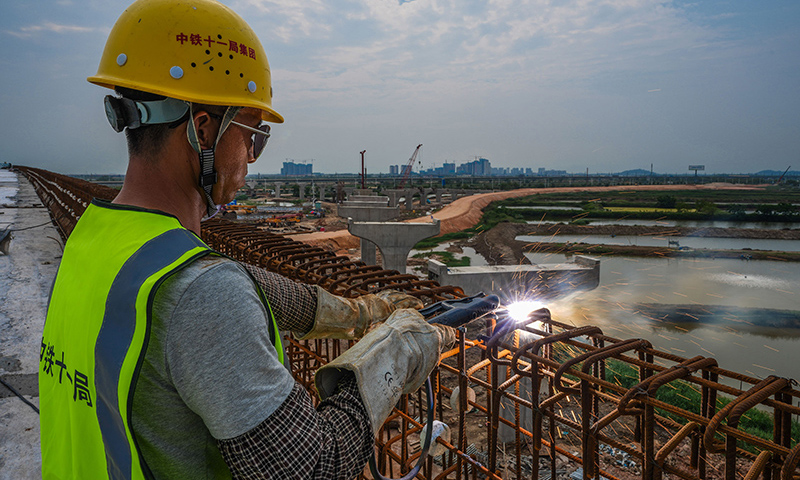 图为5月1日，工人在珠海鹤港高速公路二期工程高栏港枢纽立交桥建设现场焊接钢筋。（新华社记者 刘大伟 摄）