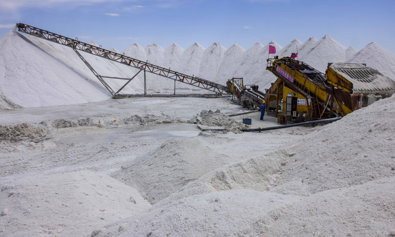 图为6月20日，在新疆和布克赛尔蒙古自治县玛纳斯盐湖，中盐宏达盐业的工人操作机器洗涤原料盐。（新华社记者 胡虎虎 摄）