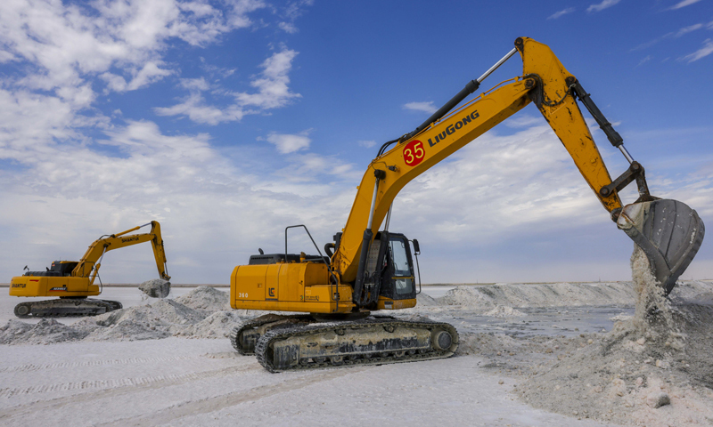 图为6月20日，中盐宏达盐业的工人在新疆和布克赛尔蒙古自治县玛纳斯盐湖中采盐。（新华社记者 胡虎虎 摄）