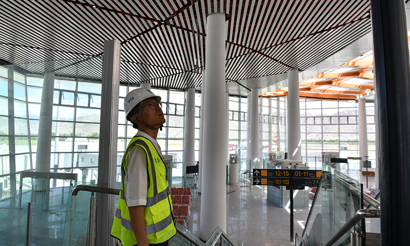 图为6月30日，施工人员在拉萨贡嘎国际机场T3航站楼内查看工程细节。（新华社记者 晋美多吉 摄）
