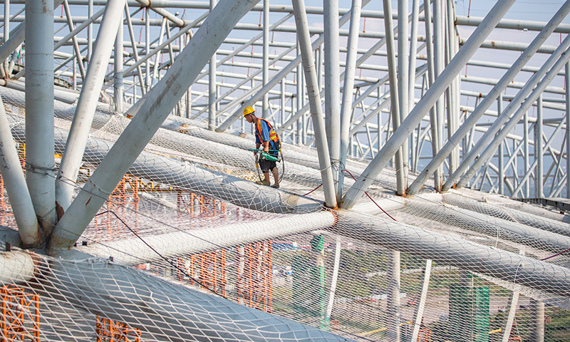 图为中建八局施工人员在重庆龙兴足球场进行屋盖钢结构施工。新华社记者 黄伟 摄