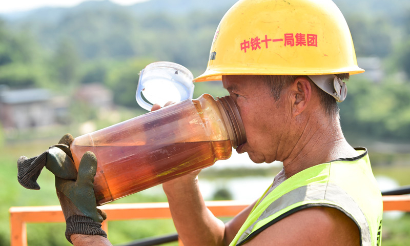 图为9月2日拍摄的渝湘高铁重庆至黔江段站前4标石家冲特大桥的施工人员在作业间隙喝水。（新华社记者 王全超 摄）