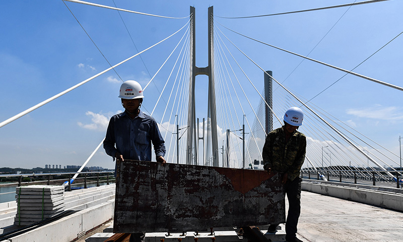 图为9月15日拍摄的施工人员在广州南沙港铁路跨西江特大斜拉桥铺轨现场作业。（新华社记者 刘大伟 摄）