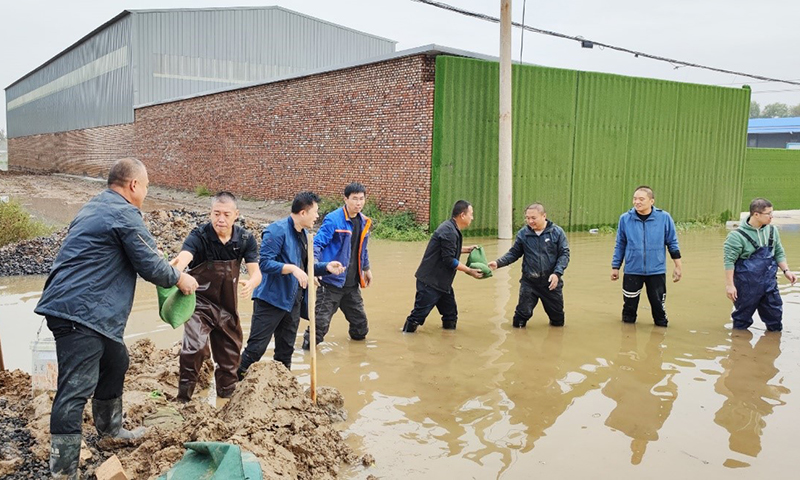 图为山西联通清徐县分公司为保证机房不被雨水浸泡，进行沙袋传递堵水渗漏。
