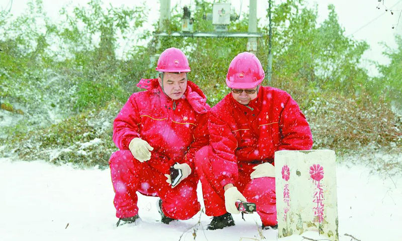 图为冀东油田北田公司输气二队巡线工正在冒雪巡线。