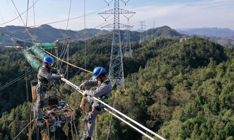 图为11月9日，安徽送变电工程有限公司施工人员在电力“天路”上施工（无人机照片）。（新华社发 赵献富 摄）