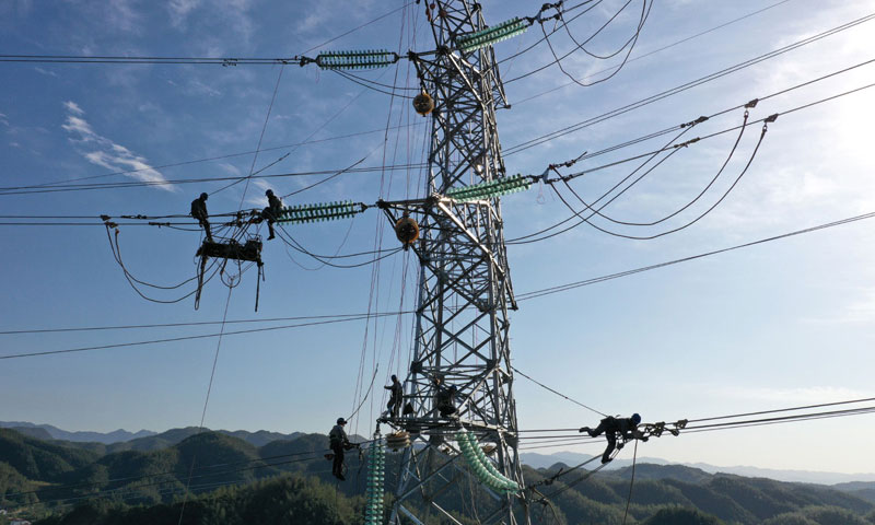 图为11月9日，安徽送变电工程有限公司施工人员在电力“天路”上施工（无人机照片）。（新华社发 赵献富 摄）