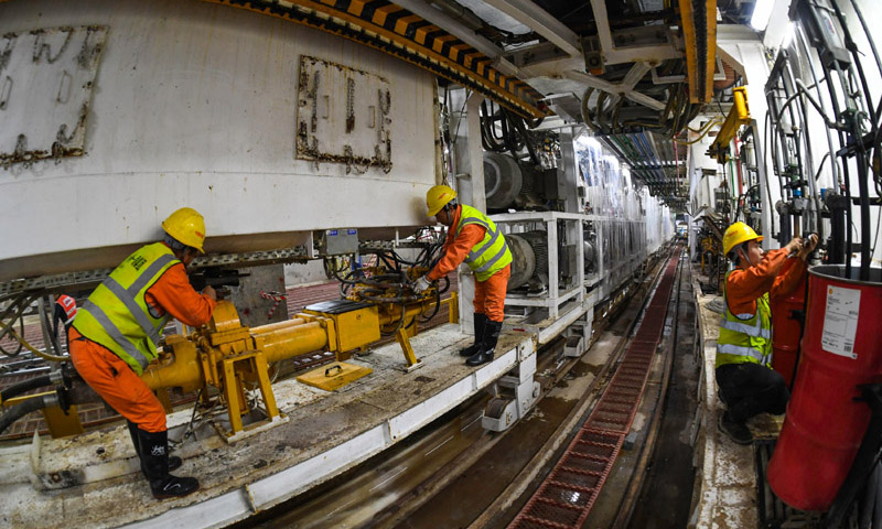 图为施工人员在广州地铁10号线东湖站盾构井检查调试盾构机设备管线。（新华社记者 刘大伟 摄）