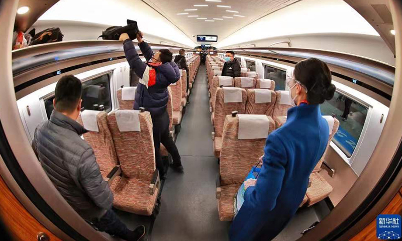 图为1月21日，乘客在G8825次列车上摆放行李。（新华社记者 刘续 摄）