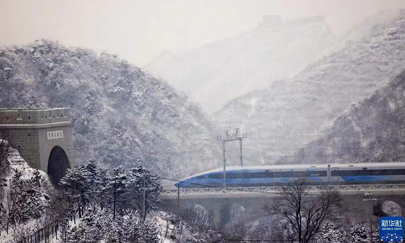 图为1月21日，G8825次列车经过居庸关隧道，冒雪驶向太子城。（新华社记者 邢广利 摄）