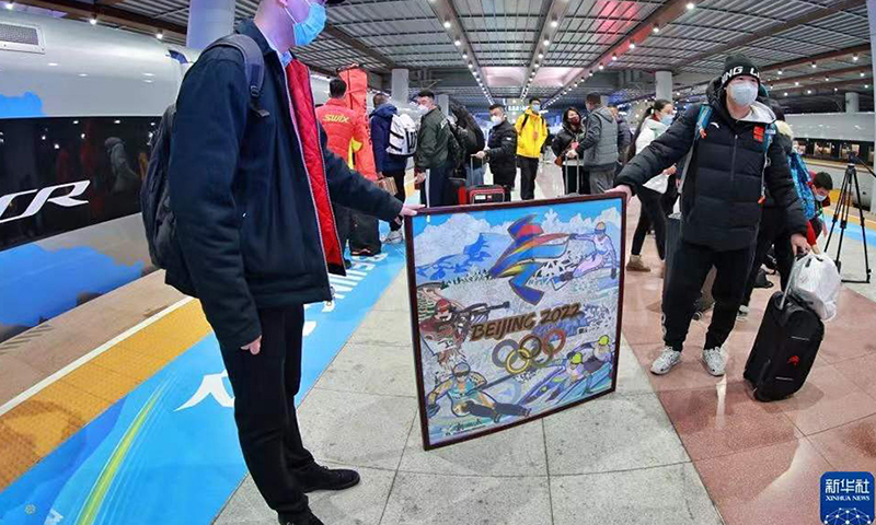 图为1月21日，乘坐G8825次列车的乘客在展示冬奥会画作。（新华社记者 刘续 摄）