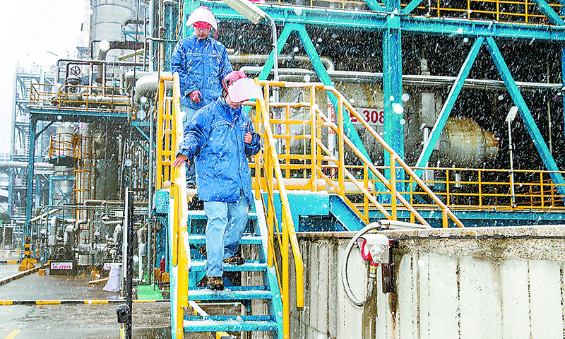 图为2月7日，扬子石化化工厂员工冒雪巡查PTA（精对苯二甲酸）装置关键部位。