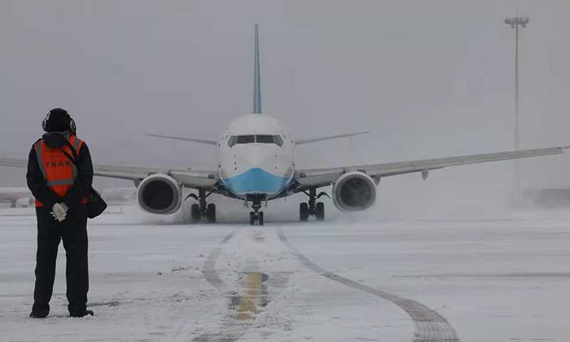 近日，云南遭遇近十年第二强的区域性寒潮天气，2月22日单日降雪范围为20年来最大，呈现降温幅度大、降雪范围广、低温持续时间长、过程降水量大等特征。图为云南空港机务积极做好冰雪天气飞机进出港及除防冰等各项工作，为昆明机场安全运行保驾护航（摄影作者：刘杨华）