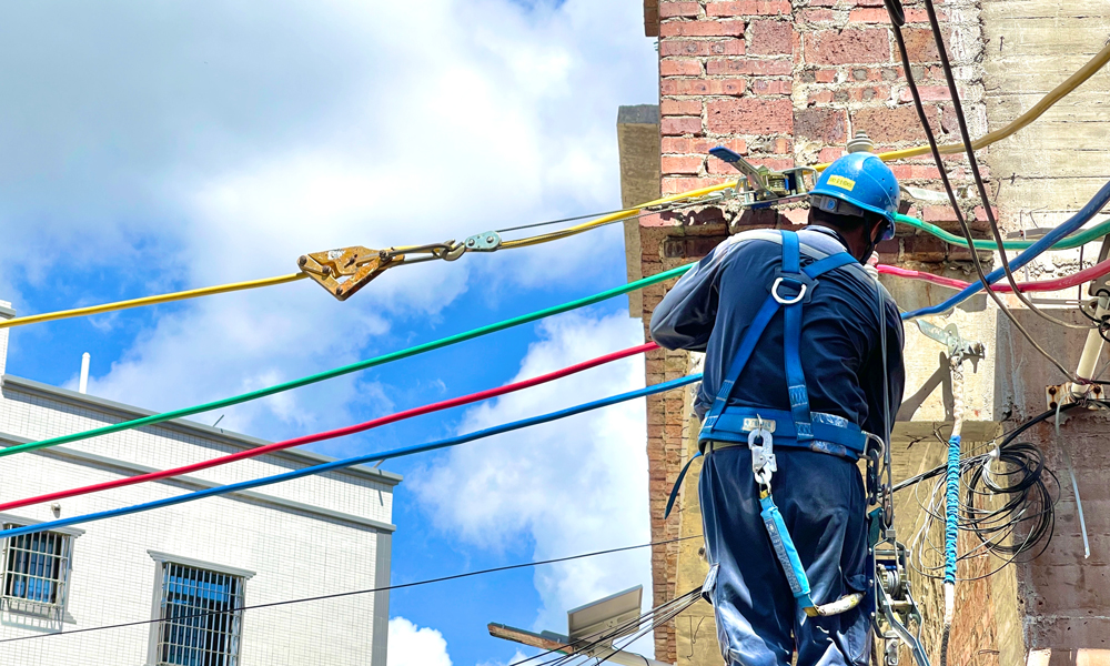 7月22日，南方电网广东湛江吴川供电局工作人员在给新建台区安装街码、架设导线。张国明 摄