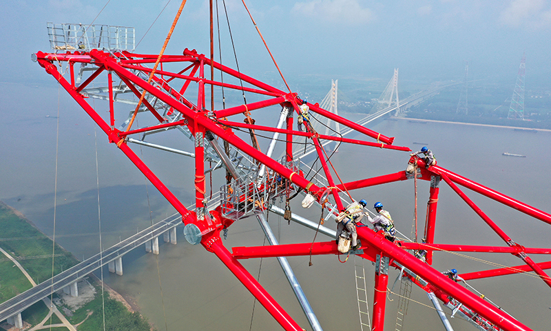 8月1日，安徽送变电工程有限公司施工人员在池州长江大跨越南岸跨越塔封顶施工现场作业（无人机照片）。赵献富 摄