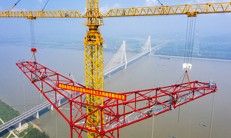 8月1日，安徽送变电工程有限公司施工人员在池州长江大跨越南岸跨越塔封顶施工现场作业（无人机照片）。郑贤列 摄