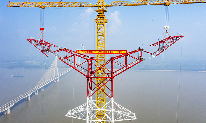8月1日，安徽送变电工程有限公司施工人员在池州长江大跨越南岸跨越塔封顶施工现场作业（无人机照片）。郑贤列 摄